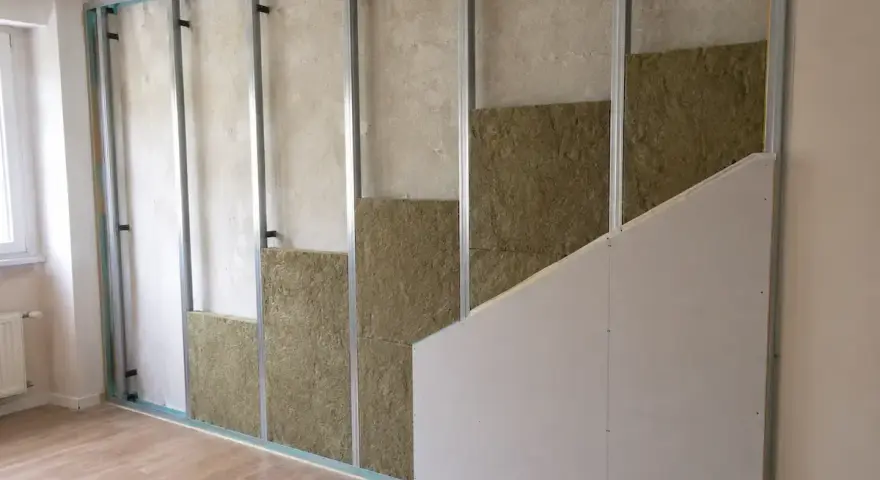 Struttura metallica per insonorizzare una stanza fai da te, con pannelli isolanti in lana di roccia e cartongesso in fase di montaggio.