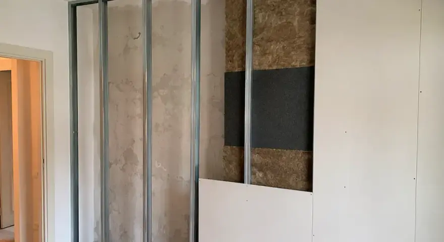 Costruzione di una parete interna con struttura metallica, isolamento acustico e pannelli in cartongesso. Si valuta lo spessore per un ottimo isolamento acustico delle pareti.