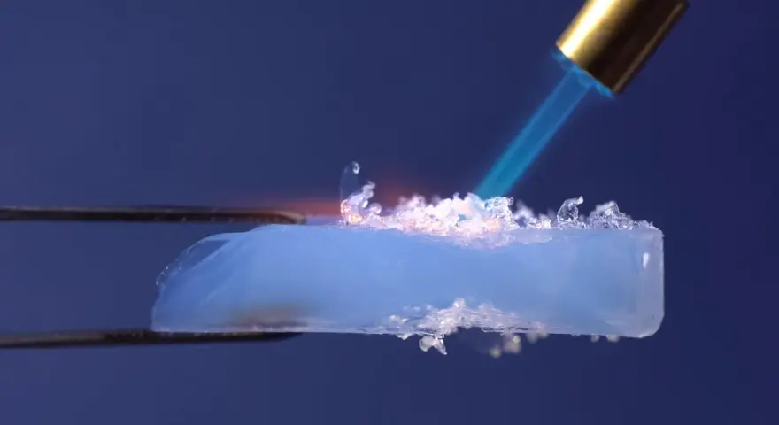 Un pezzo di aerogel, materiale innovativo per l'edilizia, viene riscaldato con una fiamma.