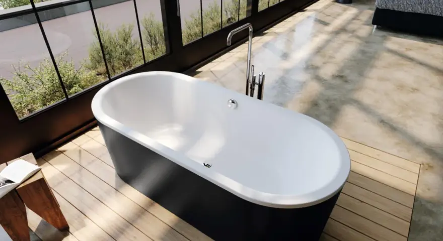 Vasca da bagno freestanding nera e bianca, con rubinetteria a colonna. L'altezza della vasca da bagno in muratura è ideale per un bagno moderno.