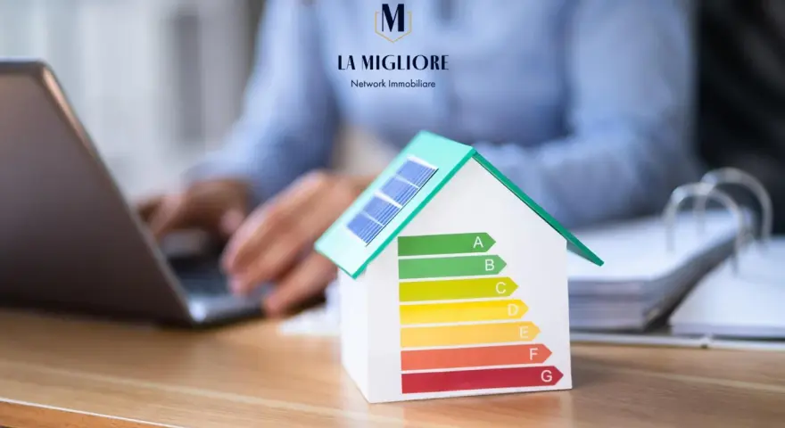 Modello di casa con pannelli solari e scala di efficienza energetica. La migliore immobiliare valuta la classe energetica casa.