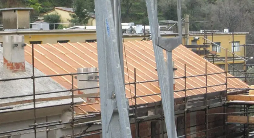 Lavori in corso per l'isolamento tetto laterocemento. Ponteggi e struttura in legno per il nuovo tetto.