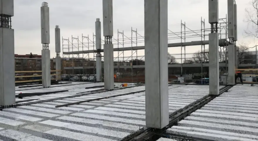 Costruzione in corso con pilastri in cemento e solai prefabbricati in attesa di completamento.