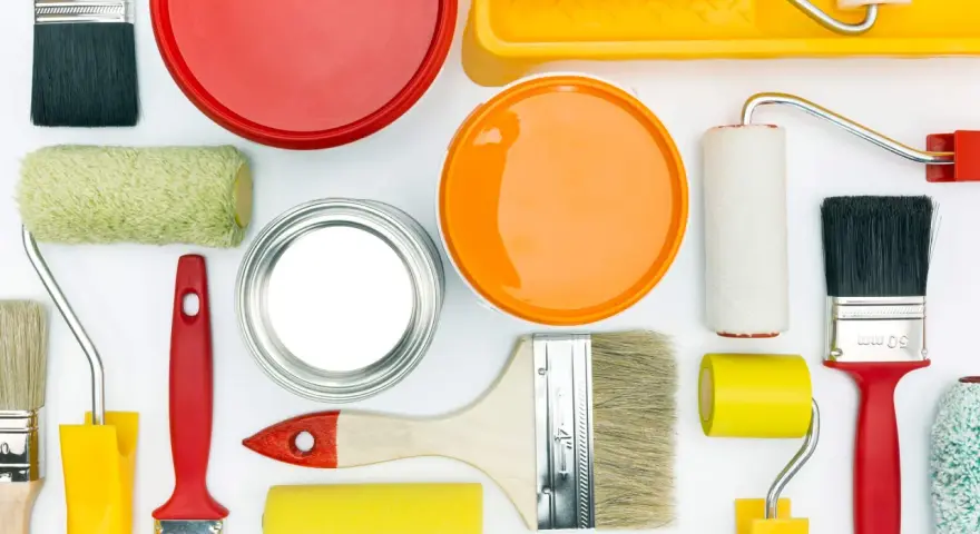 Pennelli, rulli e barattoli di vernice colorata, pronti per dipingere e come evitare i segni del rullo in controluce.