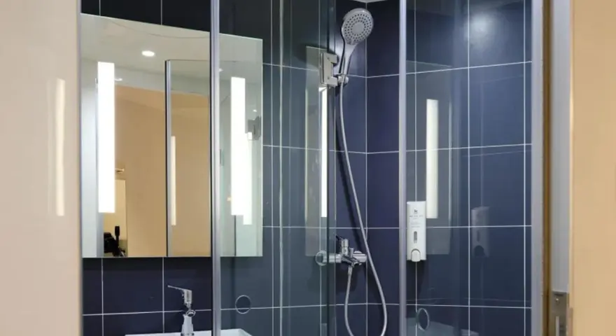 Doccia moderna con piastrelle blu. Valuta il costo sostituzione piatto e box doccia per un bagno rinnovato.