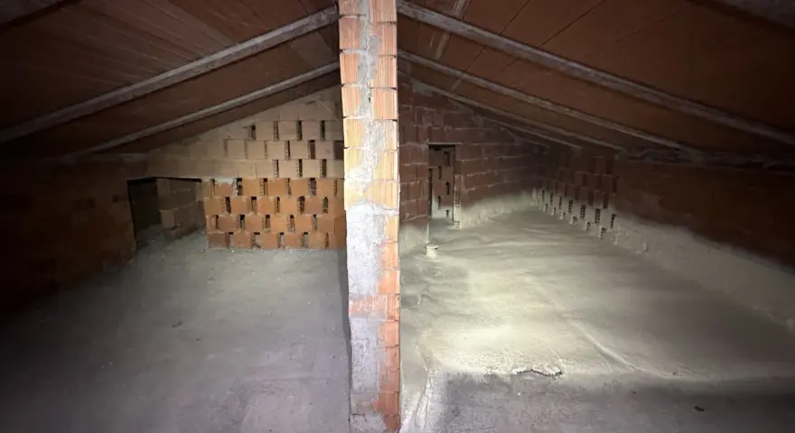 Sottotetto in costruzione con pareti in mattoni e tetto in legno. La lana di roccia a cosa serve? Qui si vede l'isolamento termico e acustico.
