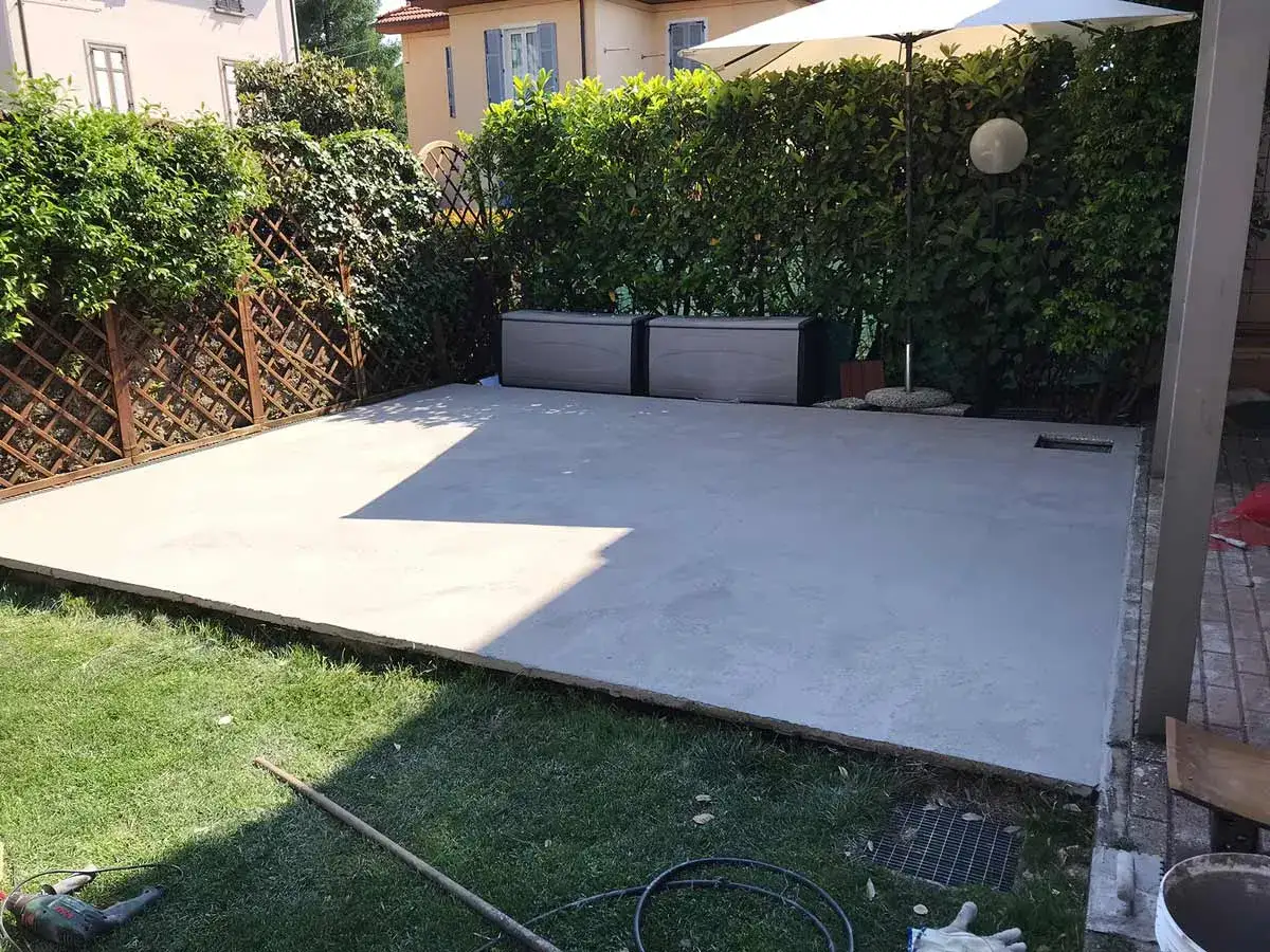 Un nuovo pavimento esterno economico fai da te in cemento, pronto per creare uno spazio vivibile in giardino.