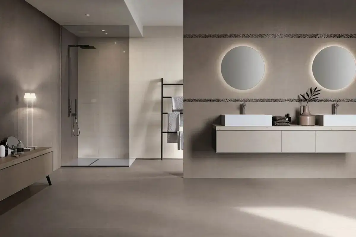 Bagno moderno con doccia walk-in e doppio lavabo. Le pareti effetto resina creano un'atmosfera rilassante e contemporanea.