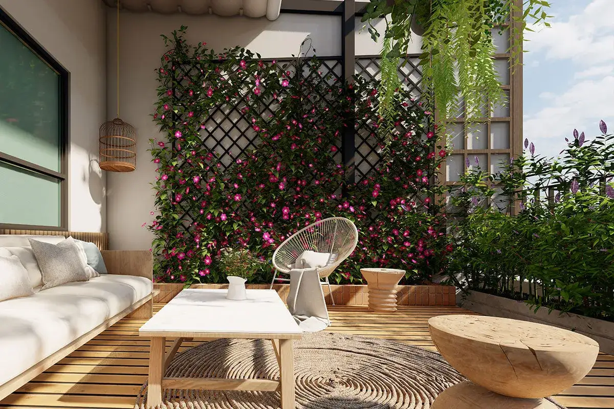 Un angolo relax con divano, tavolino e sedia, circondato da piante rampicanti che decorano muri esterni giardino con fiori rosa vivaci.