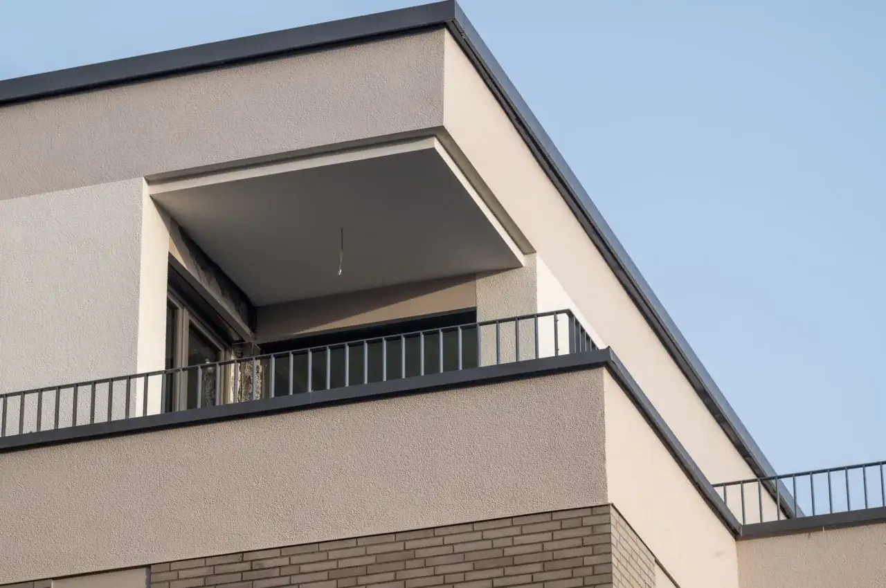 Dettagli architettonici di una casa moderna con balcone. Aiuta a scegliere colore casa esterno con finiture in intonaco chiaro e mattoni.