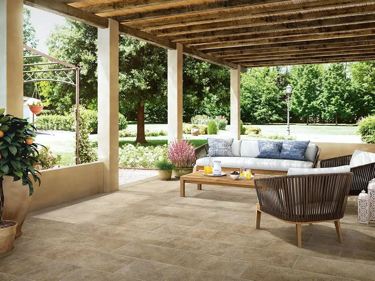 Un'area relax con divano e poltrone, perfetta per godersi il giardino dopo aver deciso di piastrellare giardino.